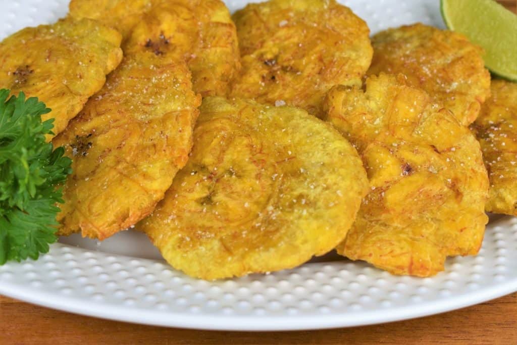 Tostones Flattened and Fried and arranged on a white plate