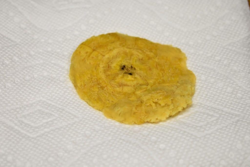 Tostones Flattened Green Plantain on a paper towel