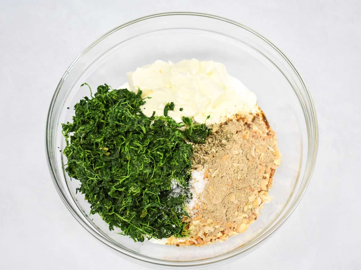 An image of the ingredients for the dip in a large glass bowl before stirring.