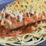 Italian Sausage Parmigiana on a bed of spaghetti