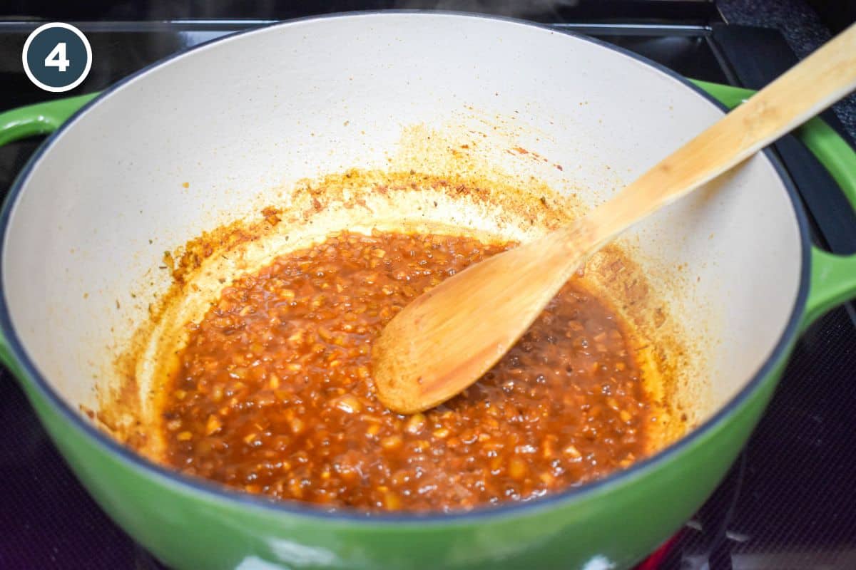Sofrito mixture simmering, deepened in color and slightly thickened.
