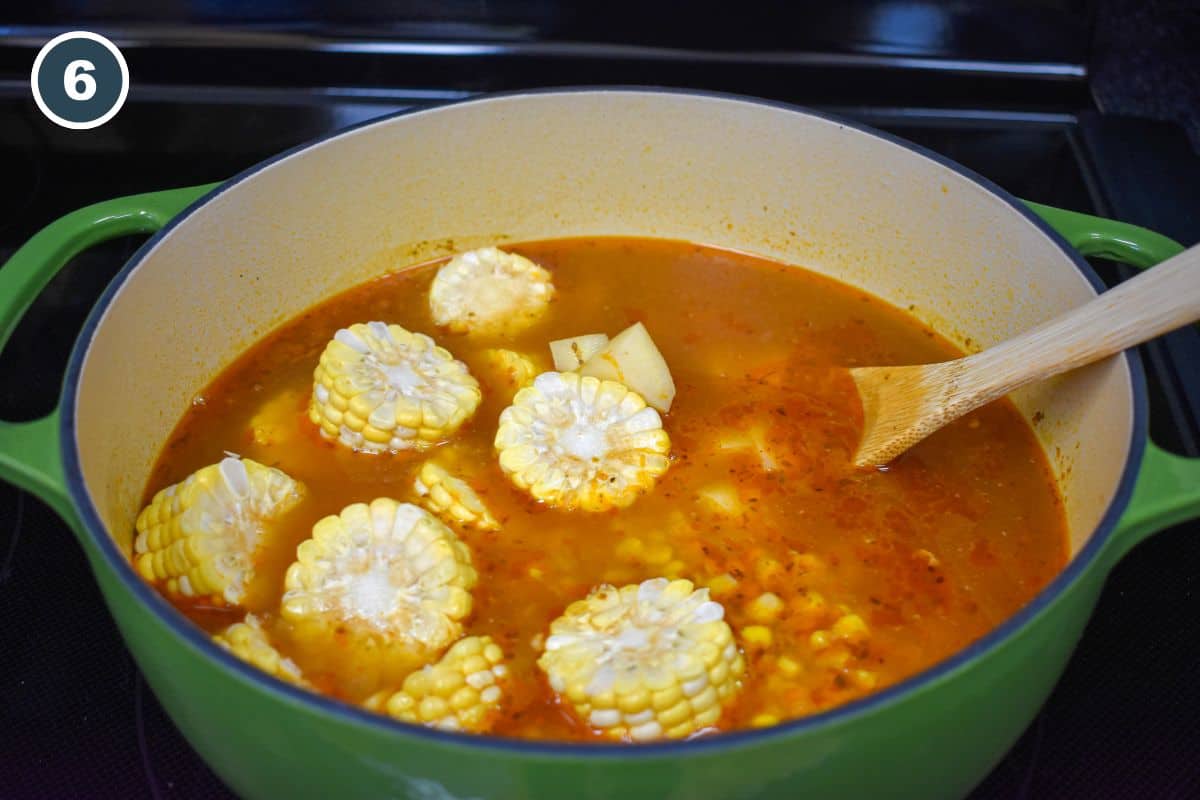 Corn cobs, corn kernels, and potatoes simmering in the broth.