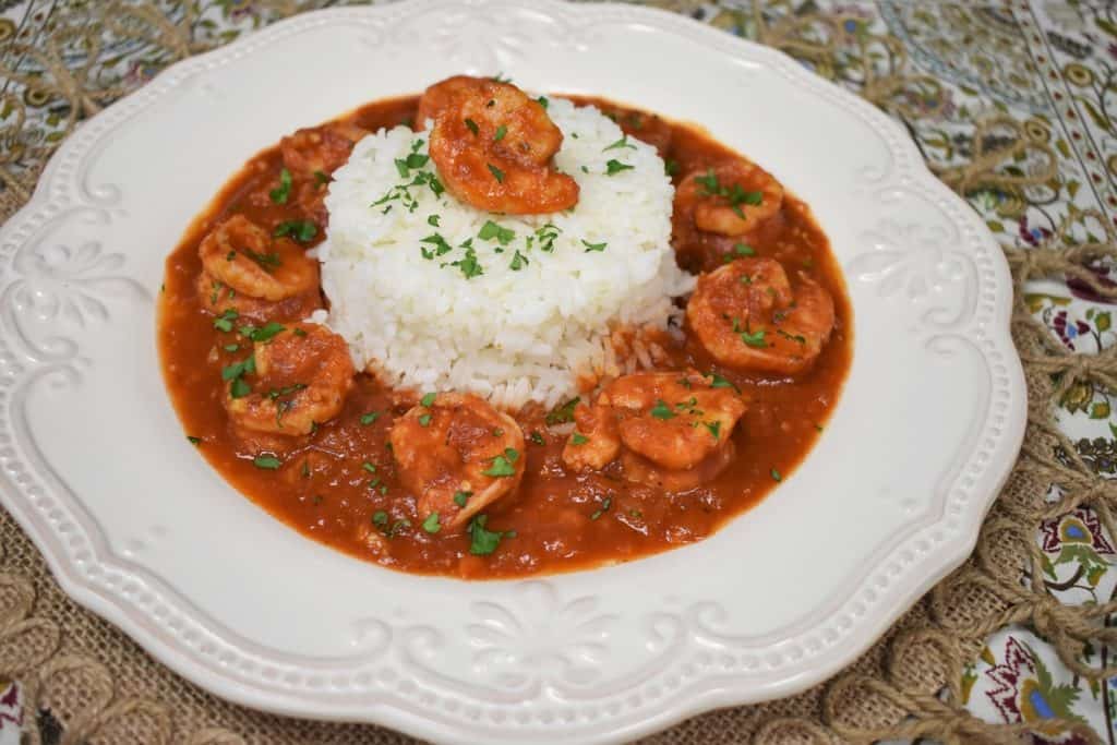 Camarones Enchilados, shrimp in a red sauce arranged around white rice and garnished with chopped parsley