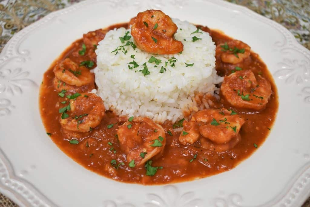 Camarones Enchilados, shrimp in a red sauce arranged around white rice and garnished with chopped parsley