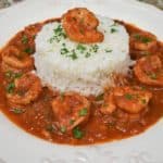 Camarones Enchilados, shrimp in a red sauce arranged around white rice and garnished with chopped parsley