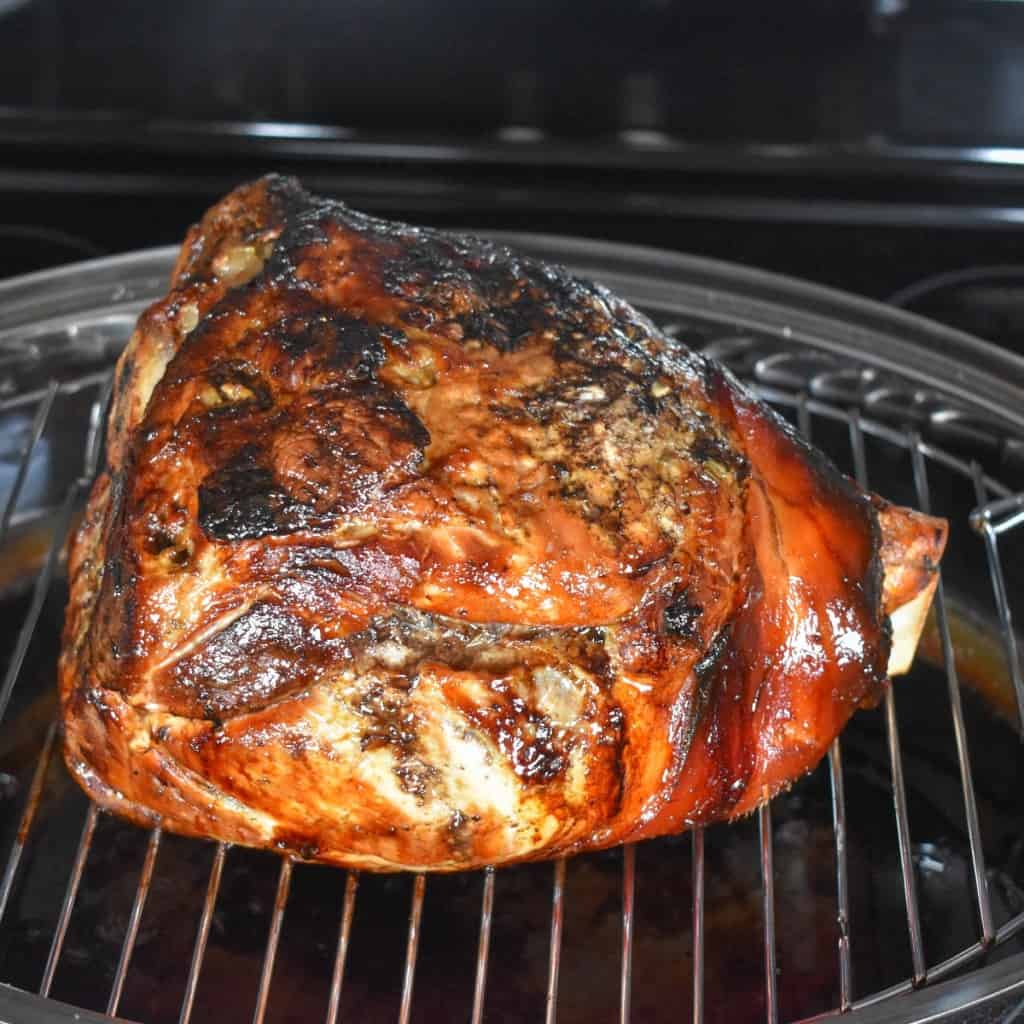 The cooked Cuban roast pork set on a roast pan with a rack.