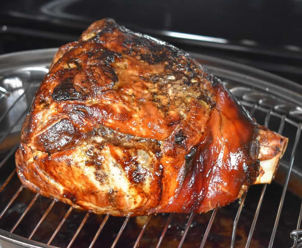 An image of the roasted pork shoulder still set on the roasting rack.