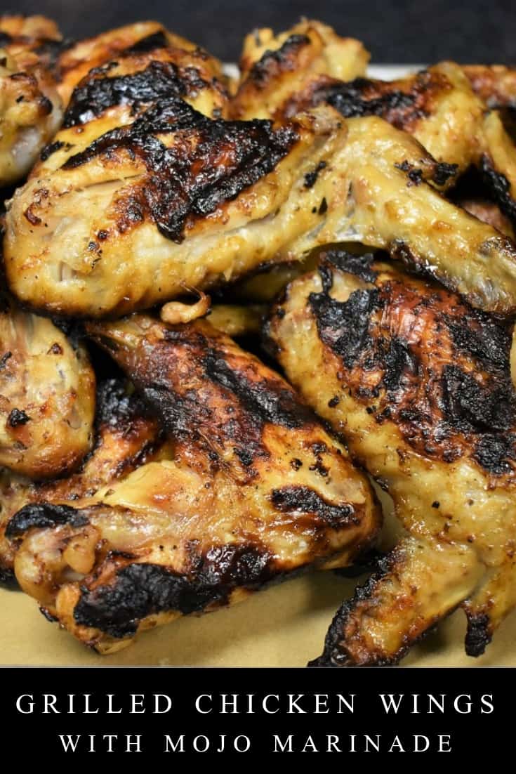 These grilled chicken wings are marinated in mojo for a tropical flair. In this recipe, whole wings are marinated in a homemade mojo that’s full of flavor thanks to sour orange juice, smashed garlic and a variety of spices. Mojo makes a great marinade for grilling. It’s just a little bit sweet, so that sour orange juice caramelizes on the chicken skin. These wings make a great appetizer; just make sure you grab a couple before they’re gone. #grilledchickenwings #mojomarinade