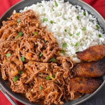 The finished ropa vieja served with white rice and fried sweet plantains on the side.