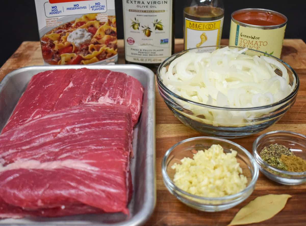 The ingredients for ropa vieja displayed on a wood cutting board.