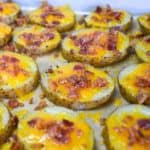 The baked potato slices arranged on a parchment paper lined baking sheet.