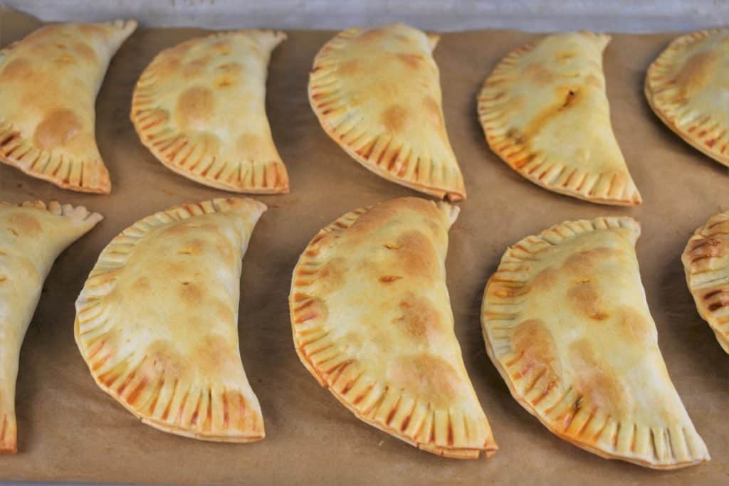 Baked Beef Empanadas arranged on a baking sheet