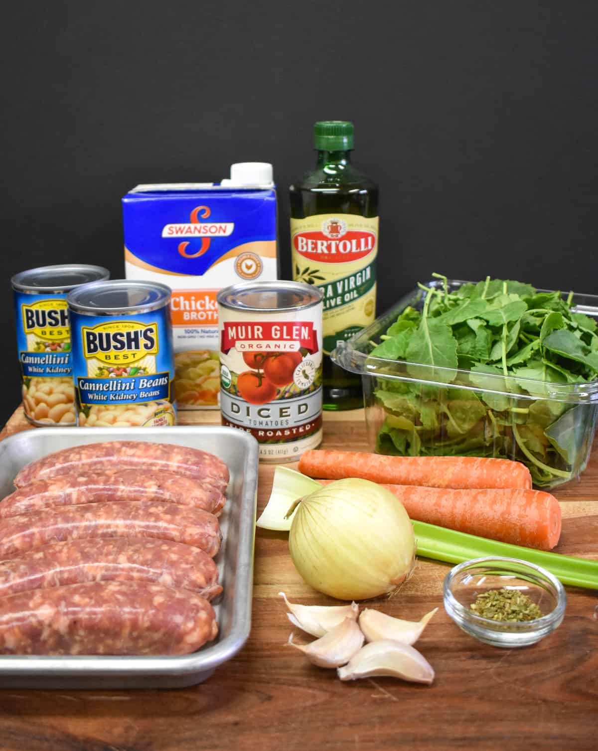 All of the ingredients for the soup displayed on a wood cutting board.