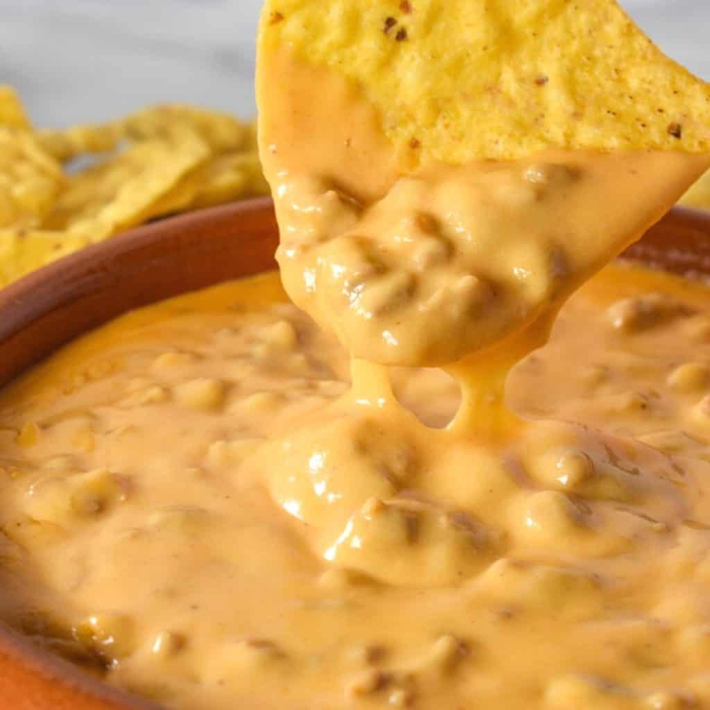 A tortilla chip dipped in the chorizo cheese dip.