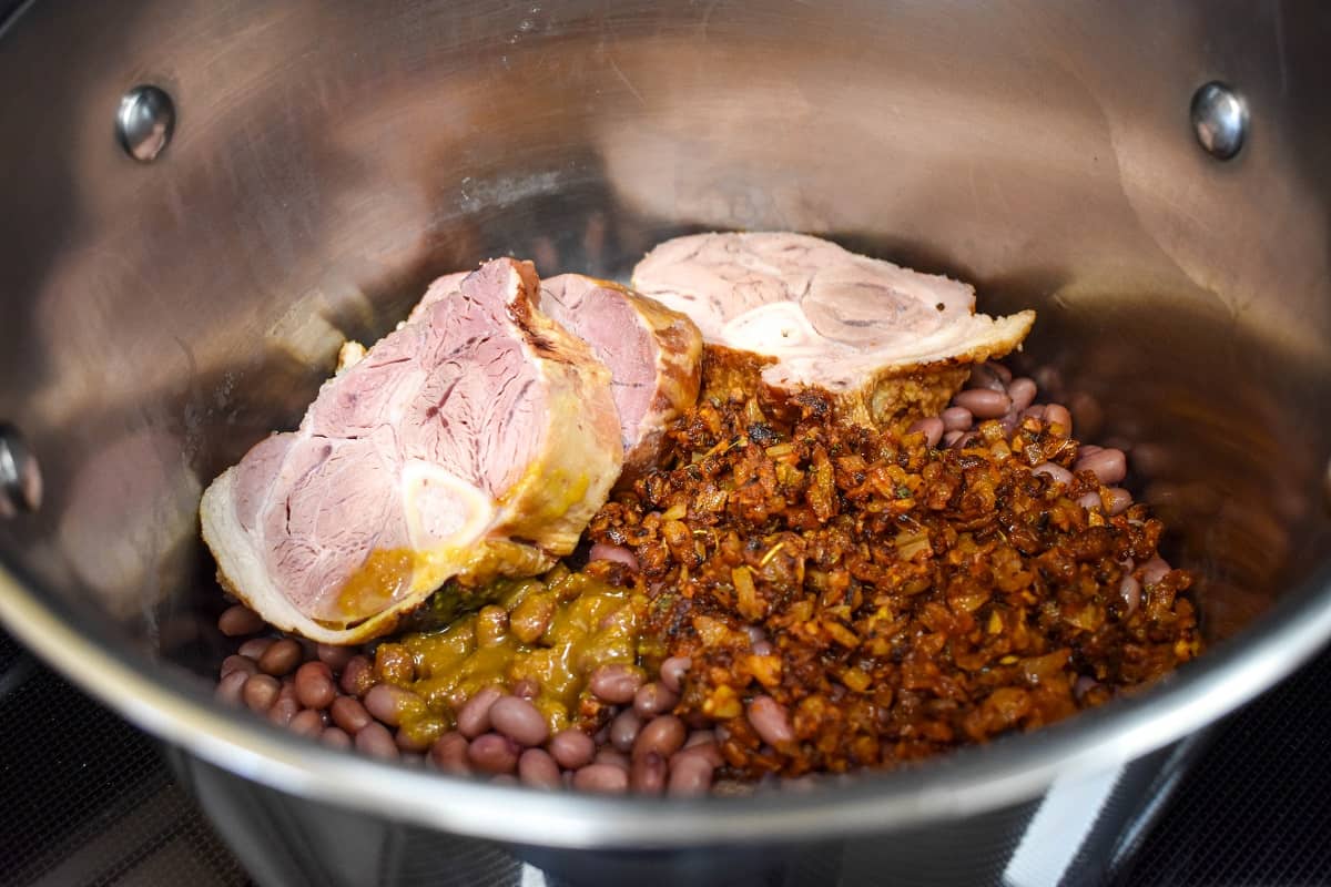 Red beans, sofrito, and ham shanks in a large pot.