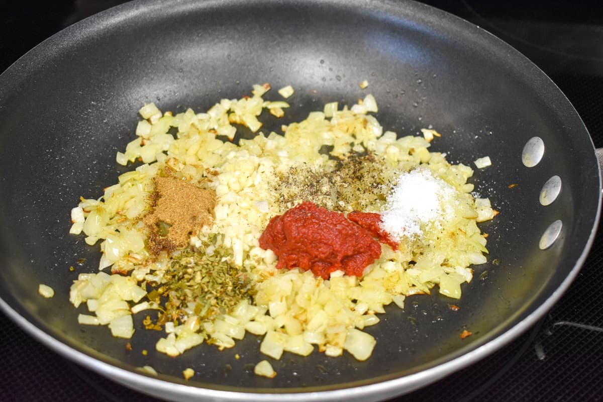 Sautéed onions with garlic, spices, and tomato paste in a non-stick skillet.