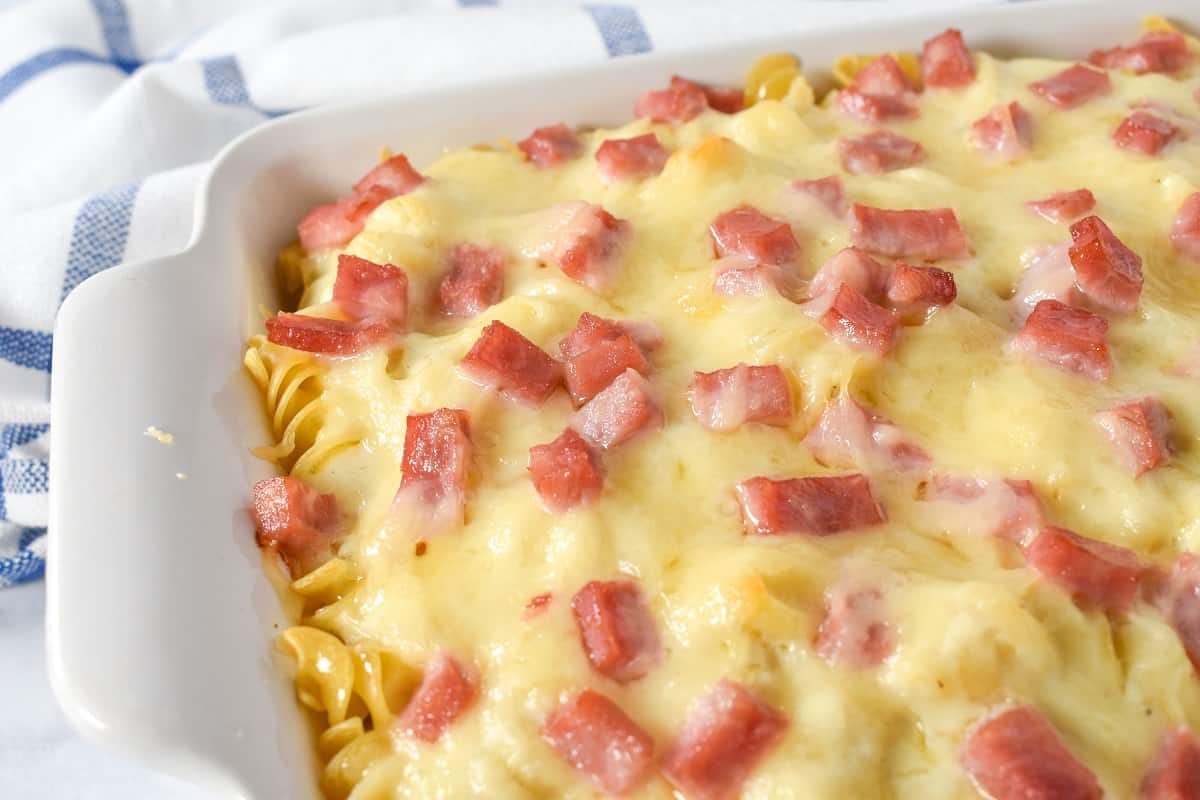 A close up of the ham and cheese casserole in a white casserole dish.