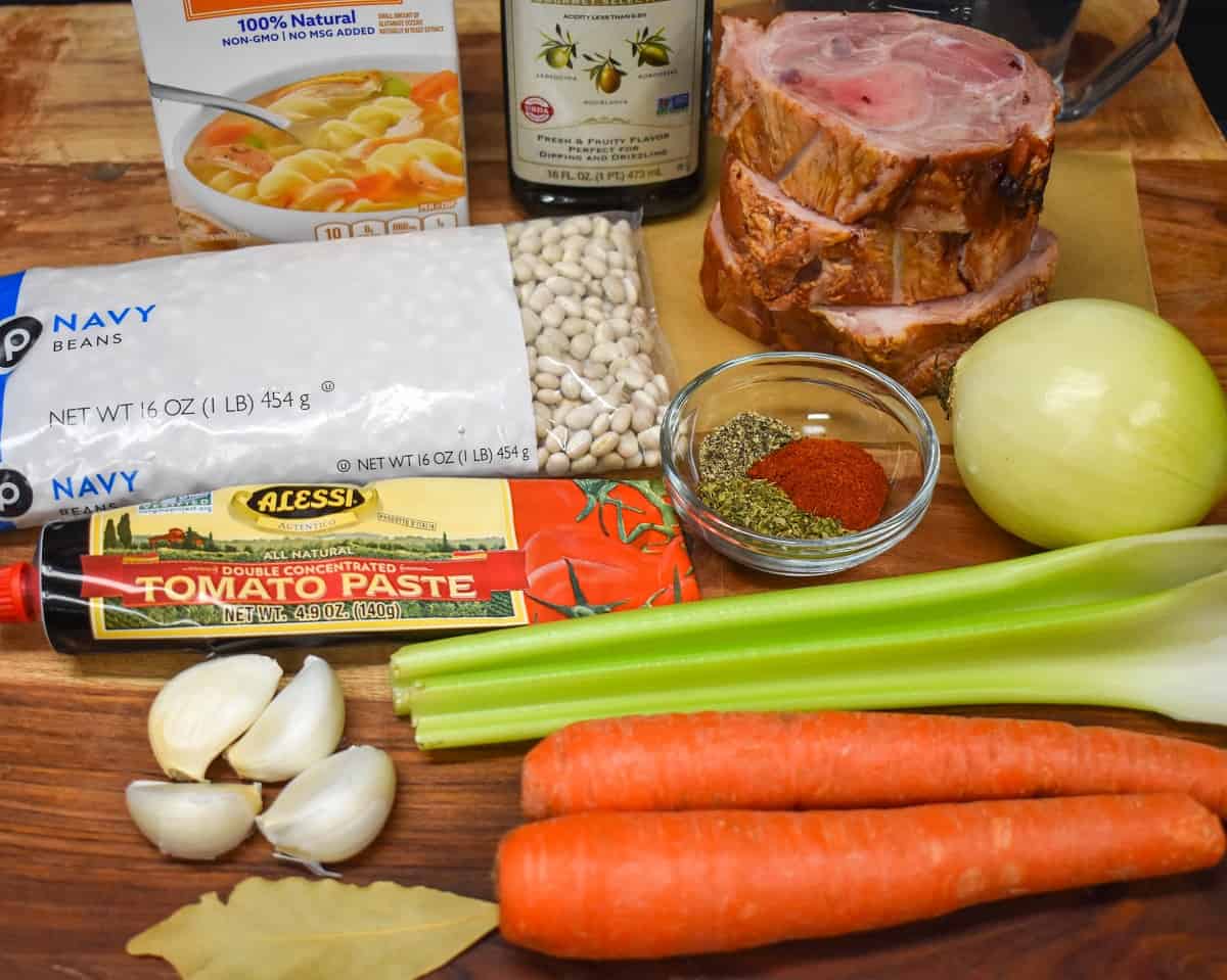 The ingredients for the navy bean soup arranged on a wood cutting board.