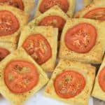 Tomato Bread puff pastry cut into squares with a thin slice of tomato in the center