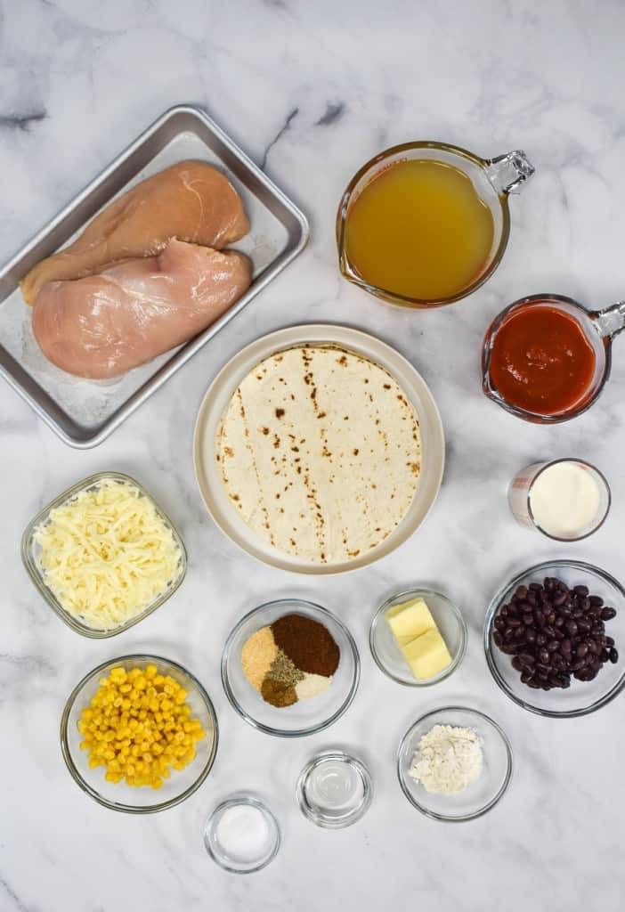 The ingredients for the recipe prepped and arranged in separate glass bowls arranged on a white table.