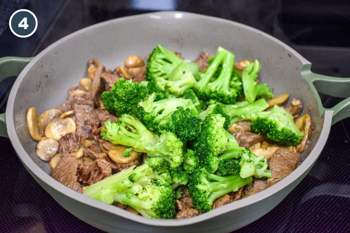 Bright green broccoli florets added to the beef and mushrooms in the skillet.