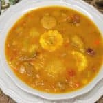 Ajiaco soup served in a large white, shallow bowl