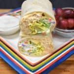 Buffalo Chicken Wrap cut in half and stacked served with ranch dressing and grapes on the side