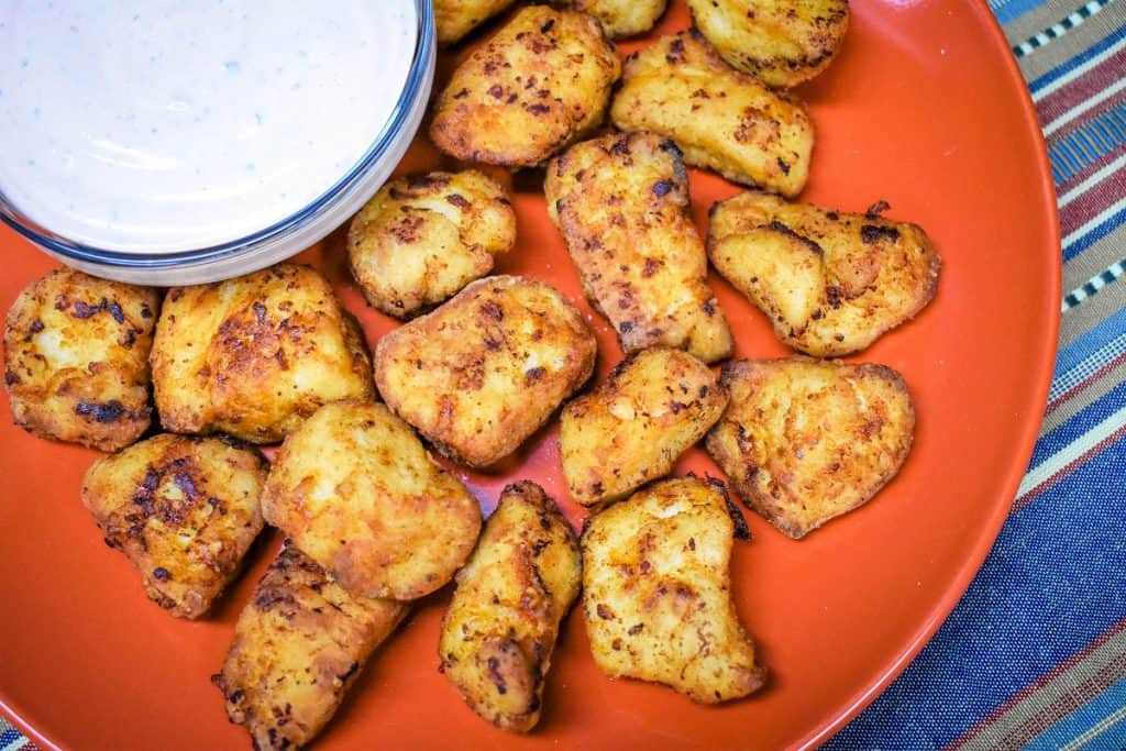 Chicken Nuggets on an orange plate with Sriracha Ranch Sauce in a clear bowl