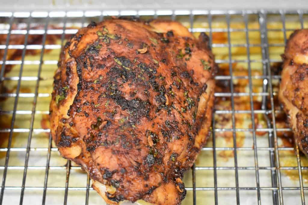 Cooked spicy baked chicken thigh on a baking sheet
