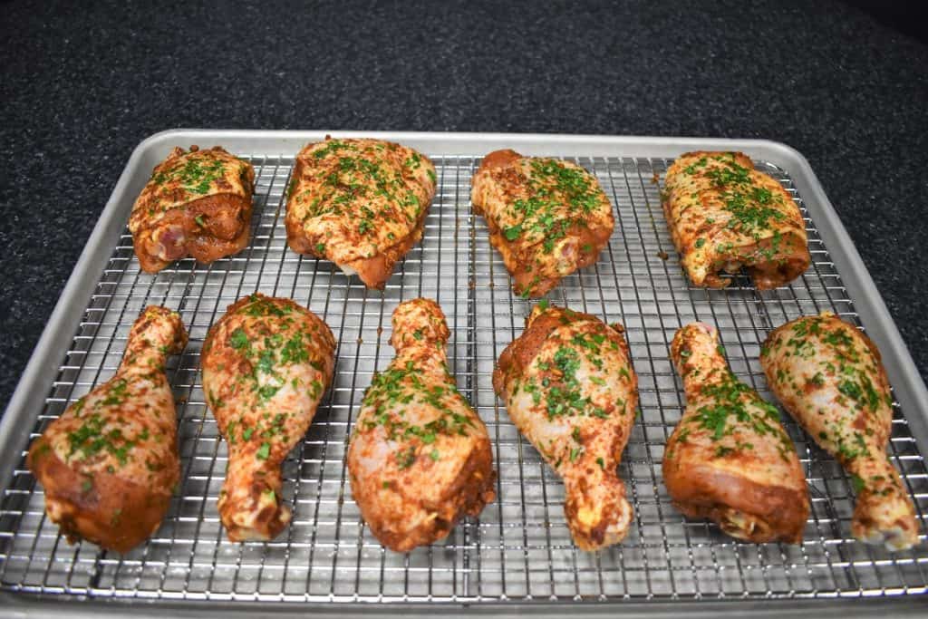 Ten pieces of seasoned raw chicken on Lined Baking Sheet