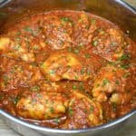 Pollo en salsa, chicken thighs in tomato sauce, in a large skillet.