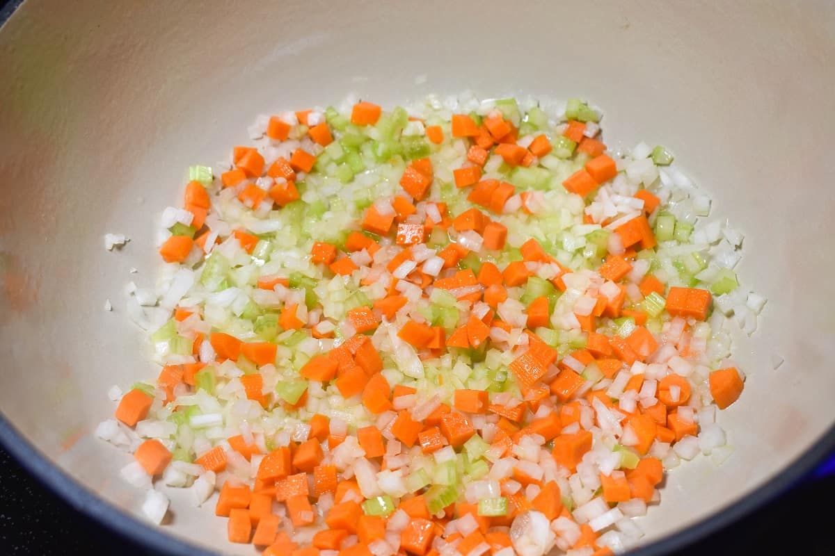 Diced onions, carrots and celery sauteing in a large pot.