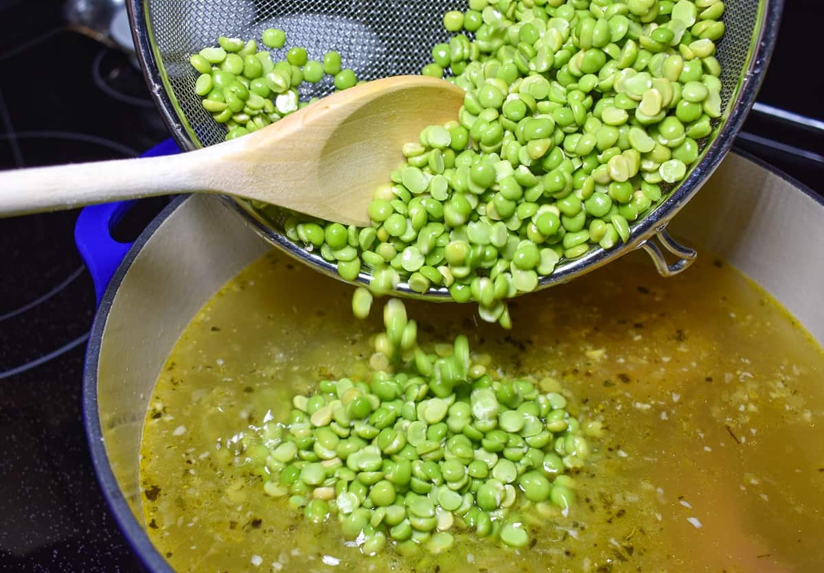 The split peas being added to the soup.