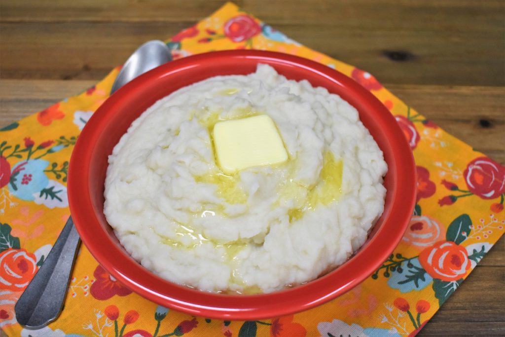 Puré de Malanga with a pat of melting butter, served in a red bowl.