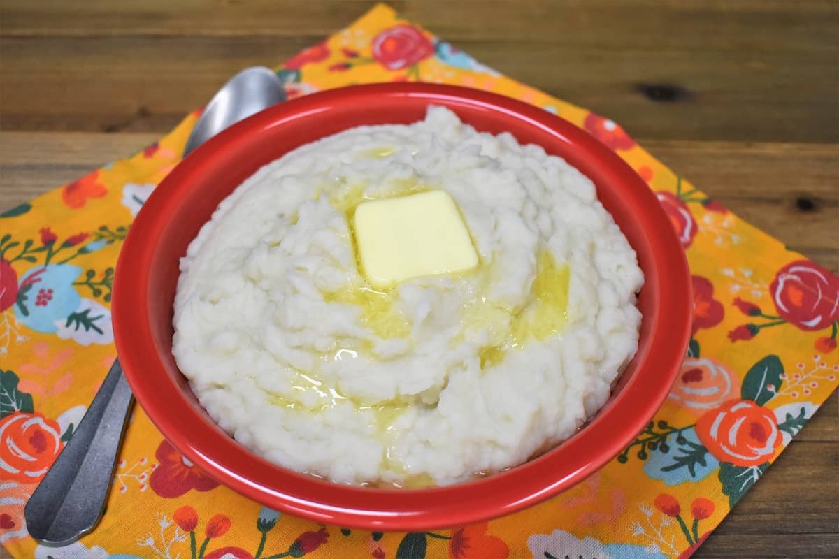 Puré de Malanga with a pat of melting butter, served in a red bowl.