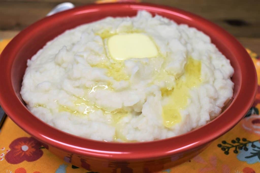 Puré de Malanga with a pat of melting butter, served in a red bowl.