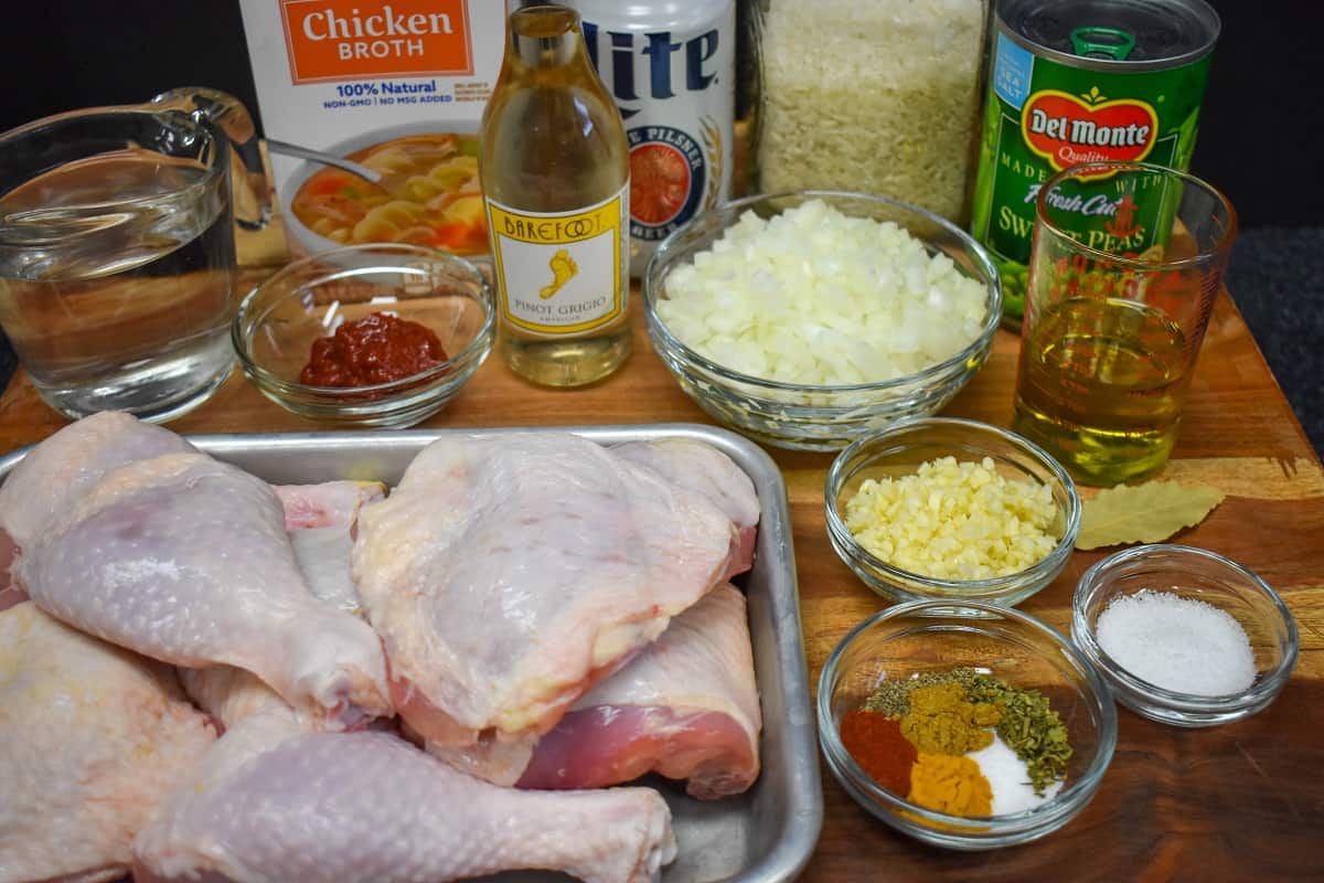The prepped ingredients for arroz con pollo arranged on a wood cutting board.