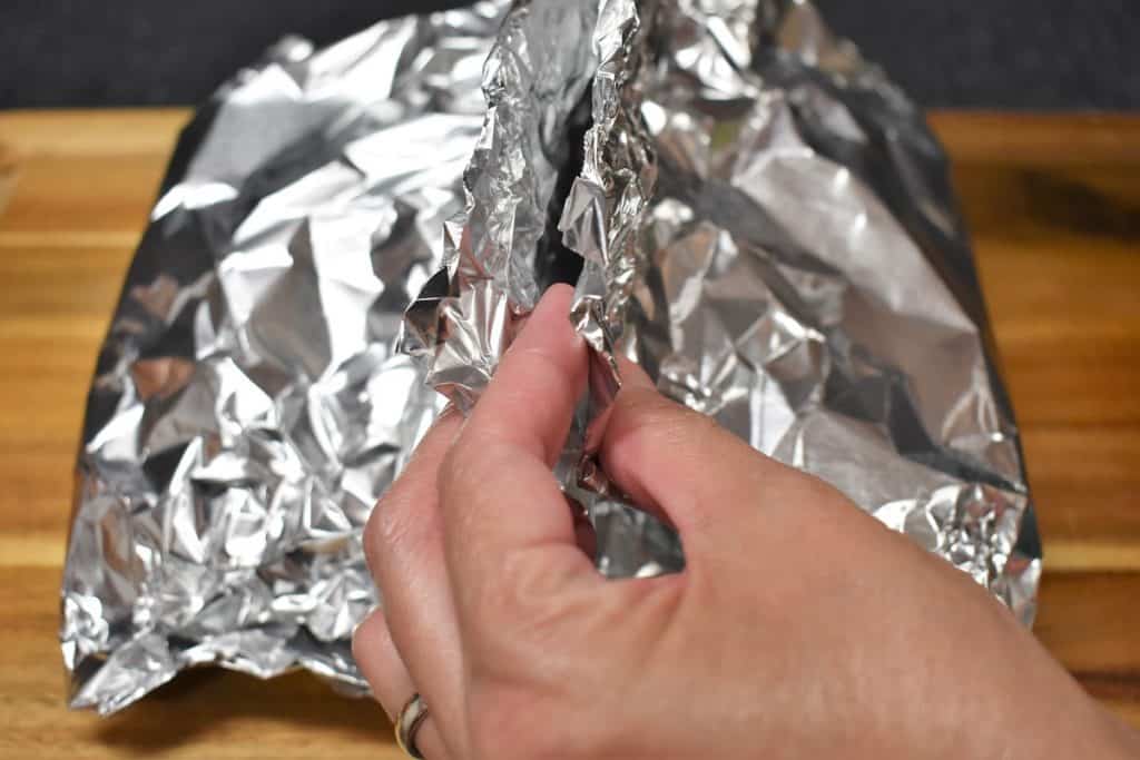 Crimping the top of a foil packet to seal.