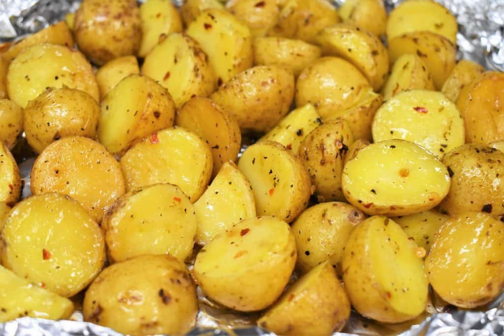 A close up picture of grilled potatoes in an open foil pack.