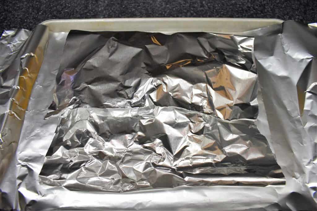 Aluminum foil folded over covering the corncobs.