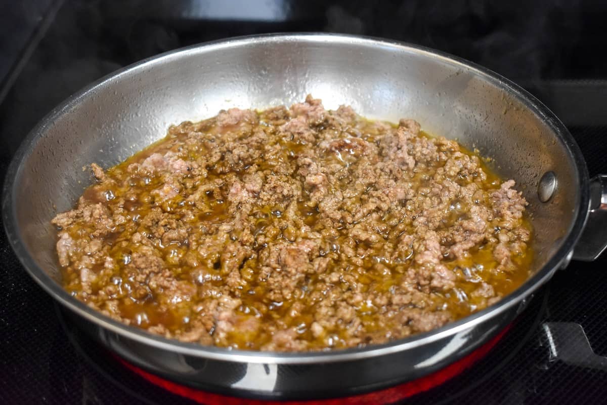 Browned ground beef in a skillet.