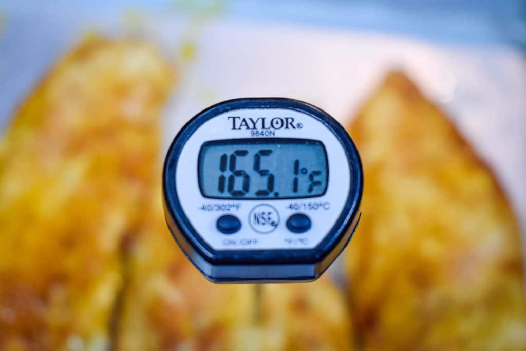An instant read thermometer registering 165 degrees.