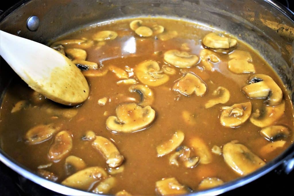 A deep brown mushroom sauce in a skillet.