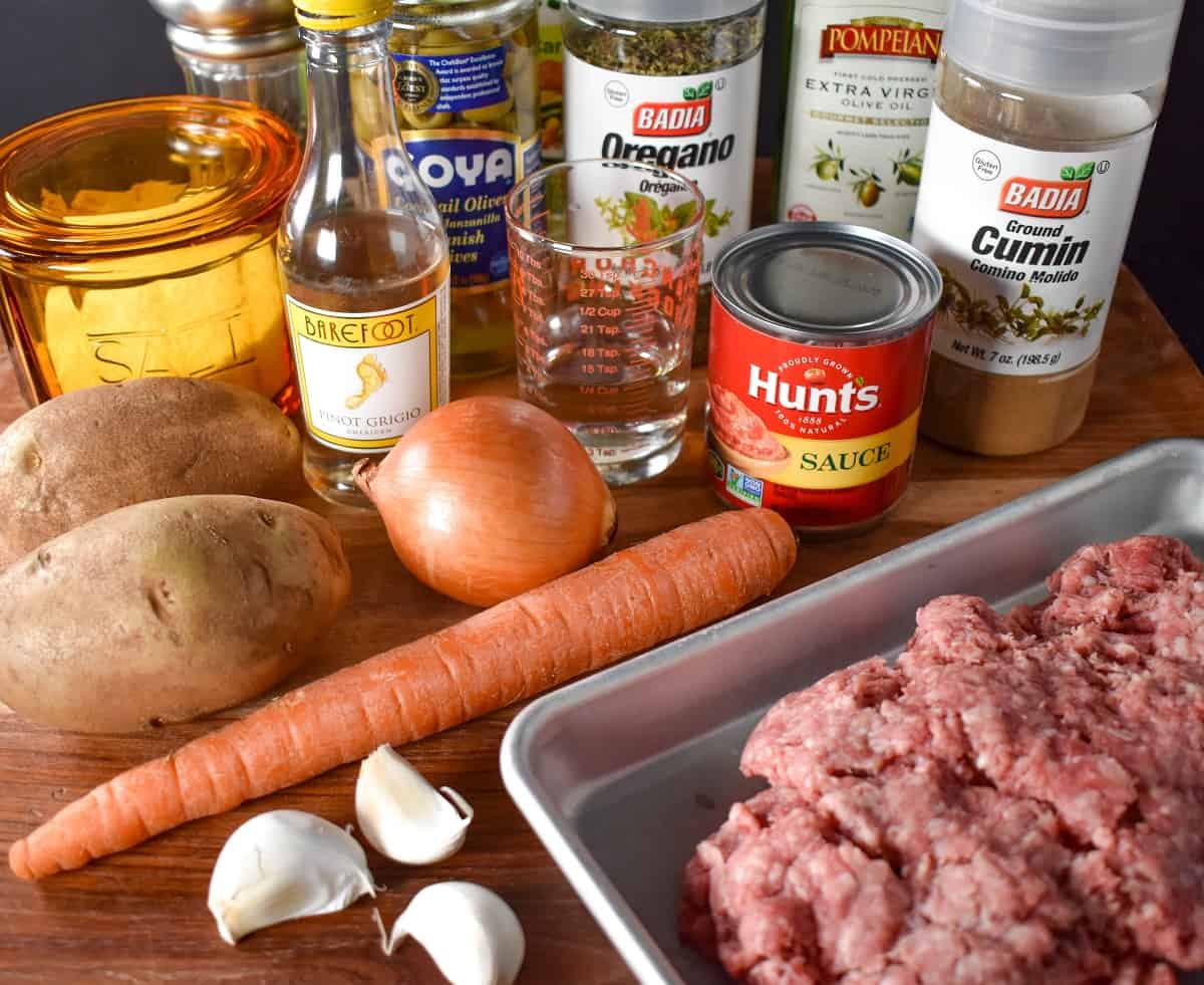 The ingredients for the dish before prepping arranged on a wood cutting board.