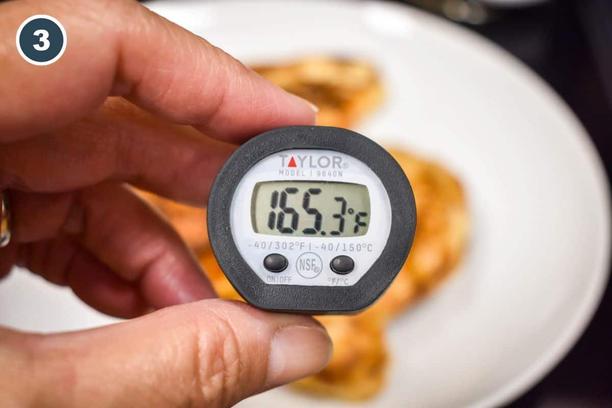 Instant-read thermometer showing chicken has reached 165°F.