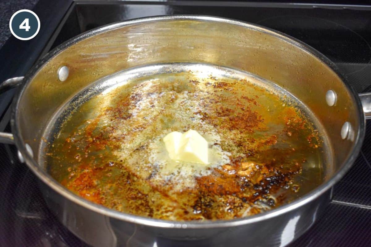 Butter melting in the skillet with browned bits from the chicken.
