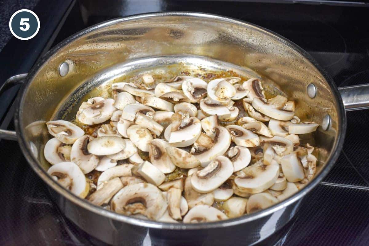 Sliced mushrooms cooking in the skillet.