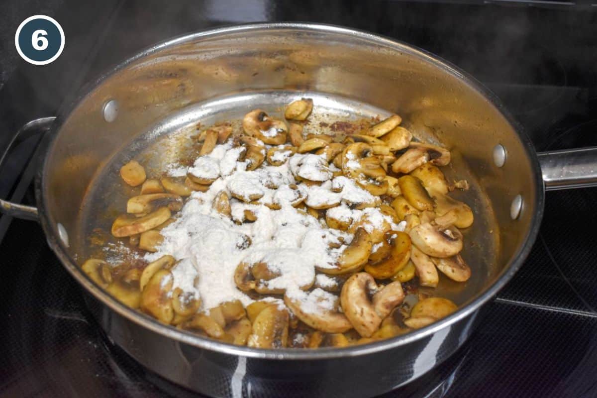 Flour sprinkled over the mushrooms in the pan.