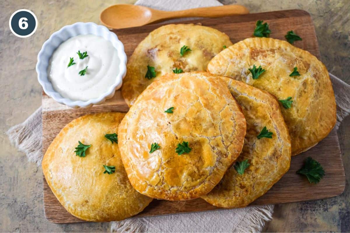 Baked golden biscuits garnished with parsley, served with dipping sauce.