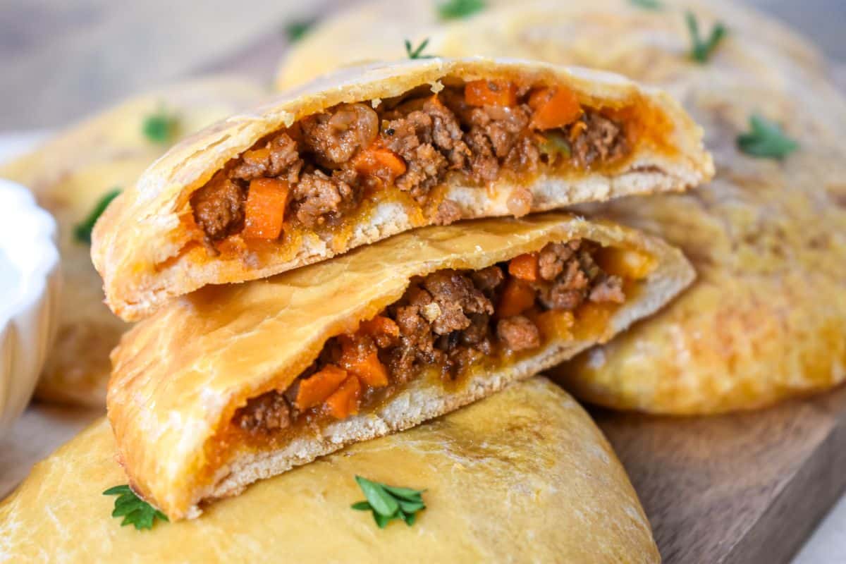A close-up of one of the biscuits cut open to show beef filling.
